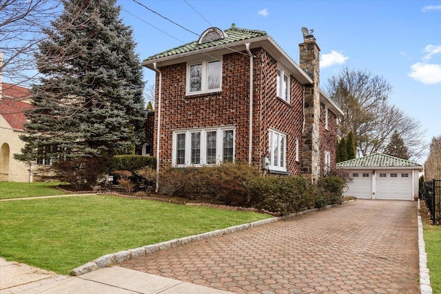 view of front of home featuring a garage, a chimney, an outdoor structure, and a front yard