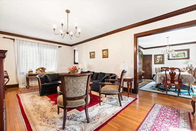 living area with light wood-type flooring, an inviting chandelier, and crown molding