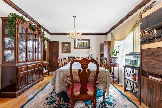 dining area featuring an inviting chandelier, light wood-style flooring, and ornamental molding