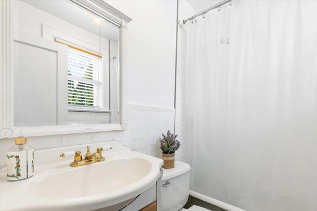 bathroom featuring vanity, tile walls, and toilet