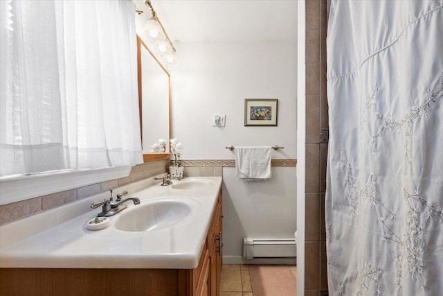 bathroom featuring tile patterned floors, baseboard heating, double vanity, and a sink