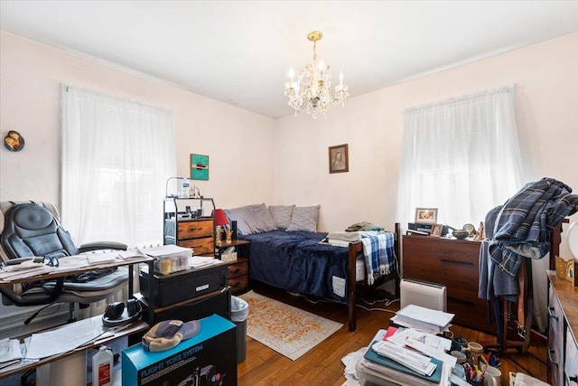 bedroom with an inviting chandelier and wood finished floors