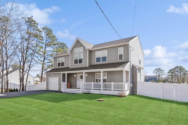 view of front facade with a front yard, covered porch, fence, and driveway