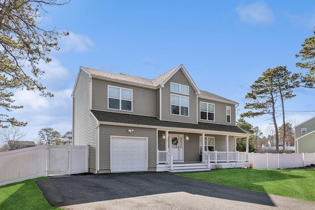 view of front of home with a porch, a front yard, fence, and driveway