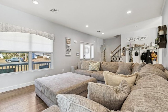 living room with baseboards, wood finished floors, visible vents, and recessed lighting