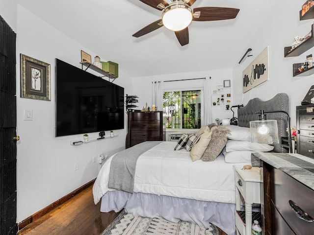 bedroom with ceiling fan, wood finished floors, and baseboards