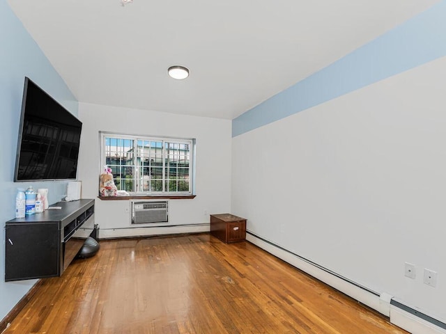 interior space with a baseboard radiator, wood finished floors, and a wall mounted air conditioner