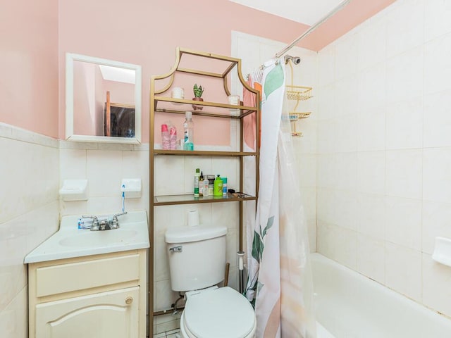 full bathroom with toilet, shower / tub combo, vanity, and tile walls