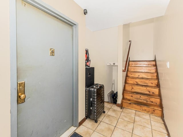 interior space with light tile patterned floors and stairway