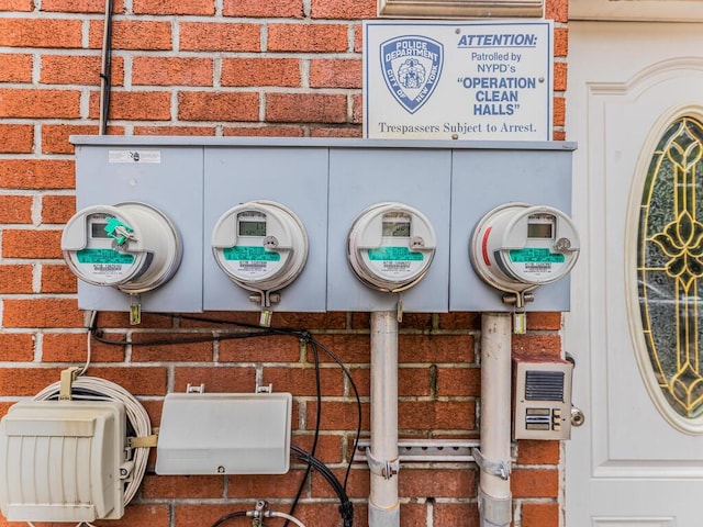 exterior details featuring electric meter and brick siding