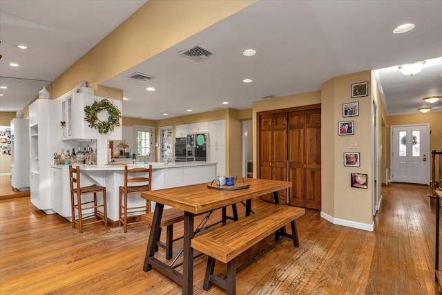 dining space featuring light wood-style flooring, visible vents, baseboards, and recessed lighting