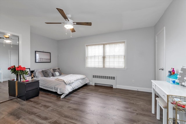 bedroom featuring baseboards, wood finished floors, and radiator