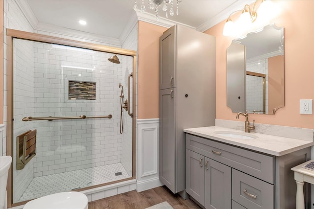 full bathroom with toilet, a stall shower, crown molding, and wood finished floors