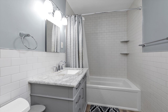 full bathroom with toilet, shower / bath combo, vanity, and tile walls