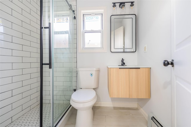 full bath with toilet, baseboard heating, a shower stall, vanity, and baseboards