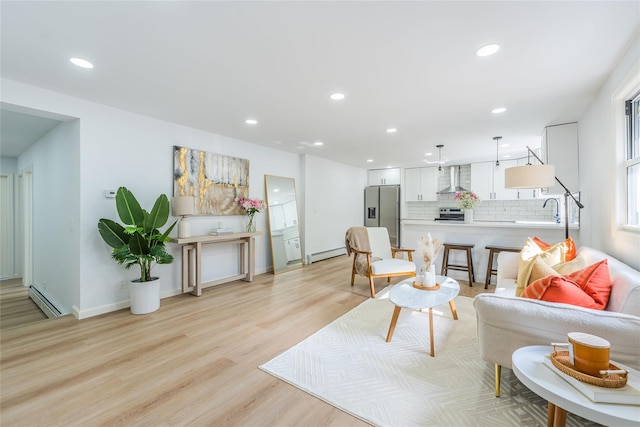 living room with a baseboard heating unit, a baseboard radiator, light wood-style flooring, and recessed lighting