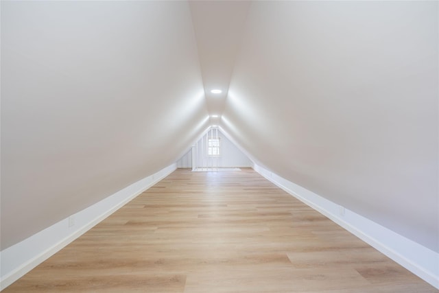 additional living space with lofted ceiling, light wood-style flooring, and baseboards