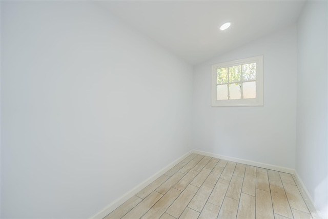 unfurnished room featuring vaulted ceiling, light wood finished floors, recessed lighting, and baseboards