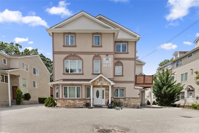 view of front of house featuring stone siding and stucco siding