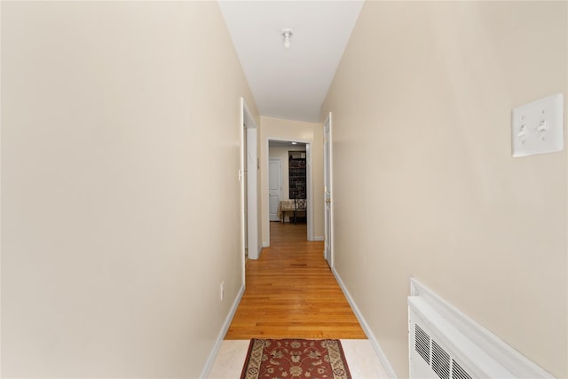 hall with light wood finished floors and baseboards