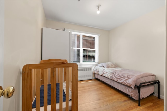 bedroom with light wood-type flooring and radiator heating unit