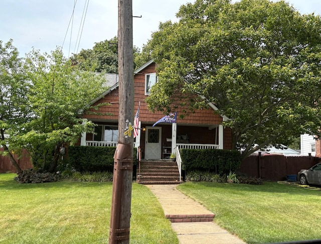 view of front of property featuring fence, a front lawn, and a porch