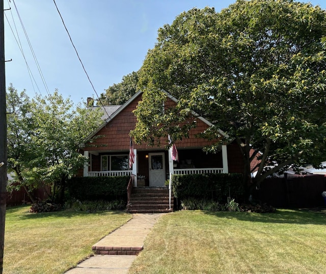 bungalow-style house featuring covered porch and a front lawn