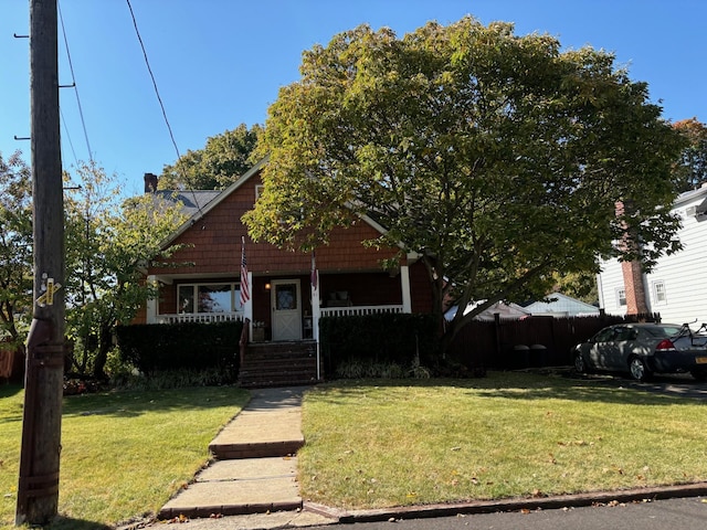 bungalow featuring a porch and a front lawn