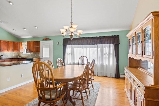 8 Rolling Woods Ln, Hampton Bays, NY 11946 - dining room with lofted ceiling, a chandelier, healthy amount of natural light, and light wood-style floors