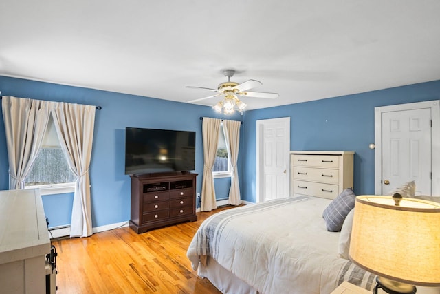 8 Rolling Woods Ln, Hampton Bays, NY 11946 - bedroom featuring multiple windows, wood finished floors, a baseboard heating unit, and a ceiling fan