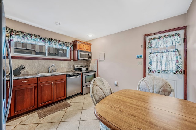 kitchen with light tile patterned floors, tasteful backsplash, stainless steel appliances, a sink, and recessed lighting