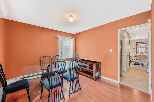 dining area with baseboards and wood finished floors