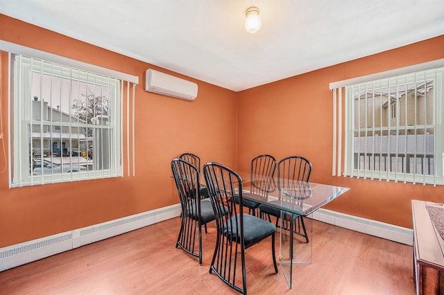 dining space featuring a baseboard heating unit, a wall mounted air conditioner, and wood finished floors