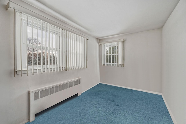 carpeted empty room with baseboards and radiator