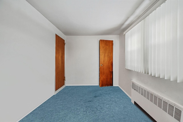 unfurnished room with carpet floors, radiator heating unit, and baseboards