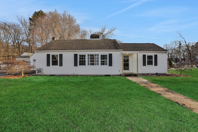 ranch-style house with a chimney and a front lawn