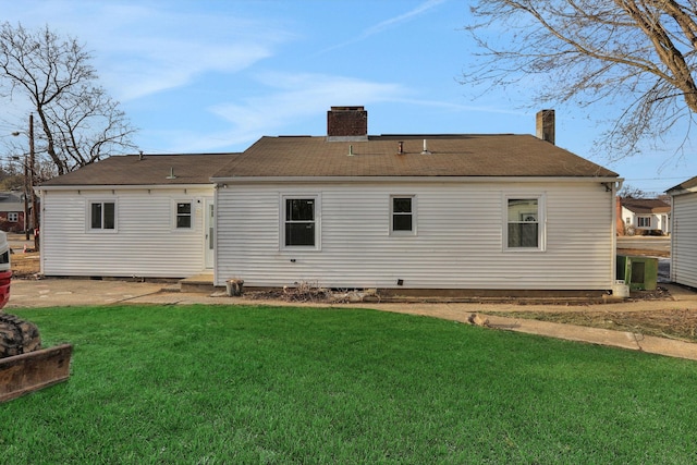 rear view of property with a yard and a chimney