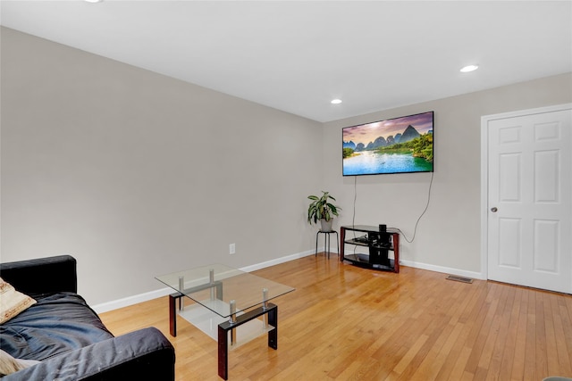 living room with light wood finished floors, baseboards, and recessed lighting