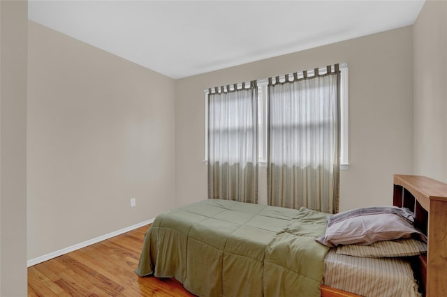 bedroom with baseboards and wood finished floors