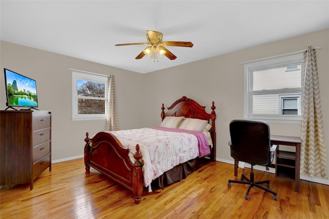 bedroom featuring a ceiling fan, baseboards, and light wood finished floors