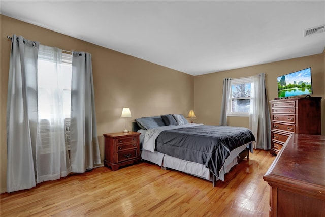 bedroom featuring light wood finished floors and visible vents