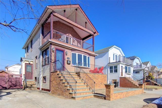 view of front of house with a balcony, a residential view, and entry steps