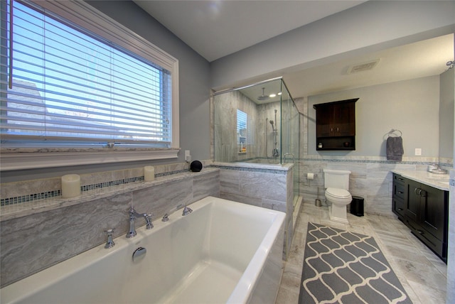 full bath featuring a garden tub, tile walls, visible vents, a shower stall, and vanity