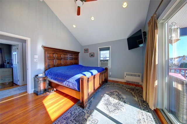 bedroom featuring baseboards, radiator heating unit, ceiling fan, wood finished floors, and high vaulted ceiling