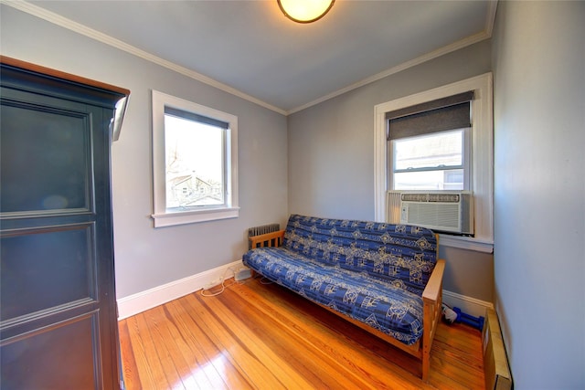 living area with ornamental molding, radiator heating unit, baseboards, and hardwood / wood-style flooring