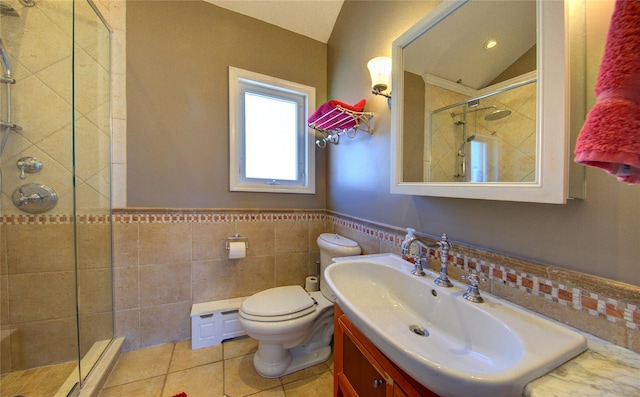 full bath with toilet, a wainscoted wall, tile patterned floors, a shower stall, and tile walls