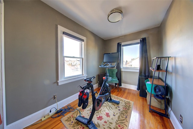 workout room with baseboards and wood finished floors