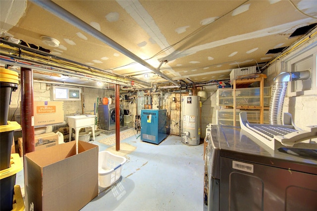 basement featuring water heater, washer and clothes dryer, and a heating unit