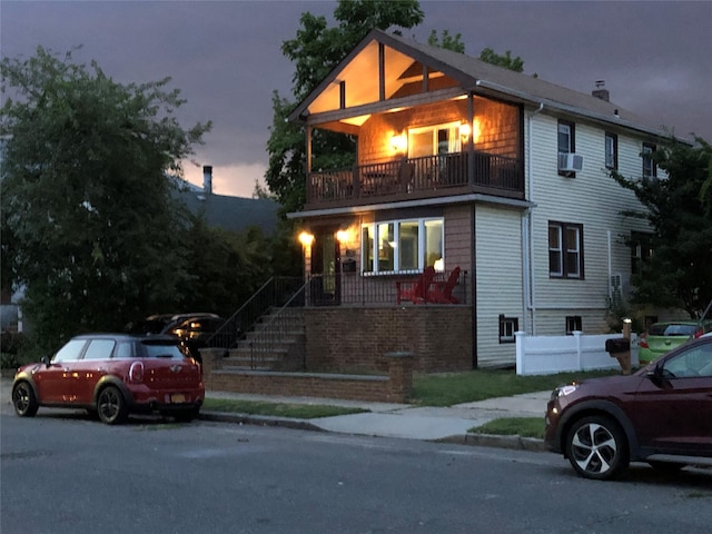 view of front of home with a balcony, stairway, and cooling unit