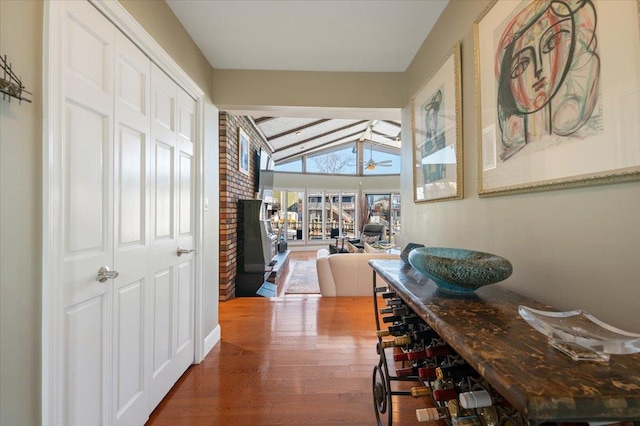 corridor featuring lofted ceiling with beams and wood finished floors